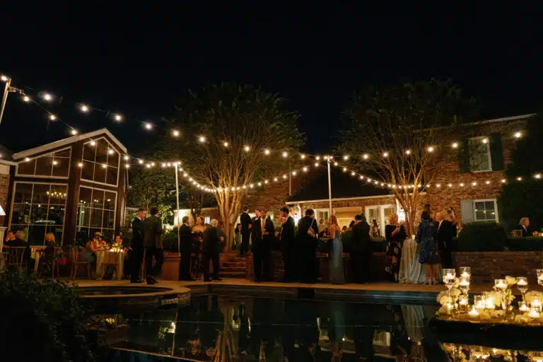 Outdoor evening gathering with string lights.
